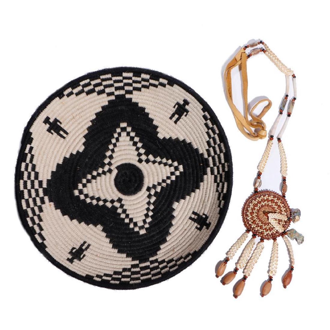 TWO NATIVE AMERICAN-THEMED ITEMS: A Northern California basketry pendant, with dentalium and abalone shell attachments; and a faithful replica of an Apache tray woven with yarn. Length of first 19 inches, diameter of second 10 1/2 inc
