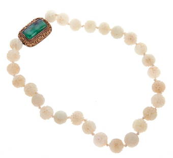 Carved jade bead necklace: beads measuring approximately 13mm, with gilt silver and jade clasp; jade in clasp measuring approximately 24 x 12mm; length: 17in.