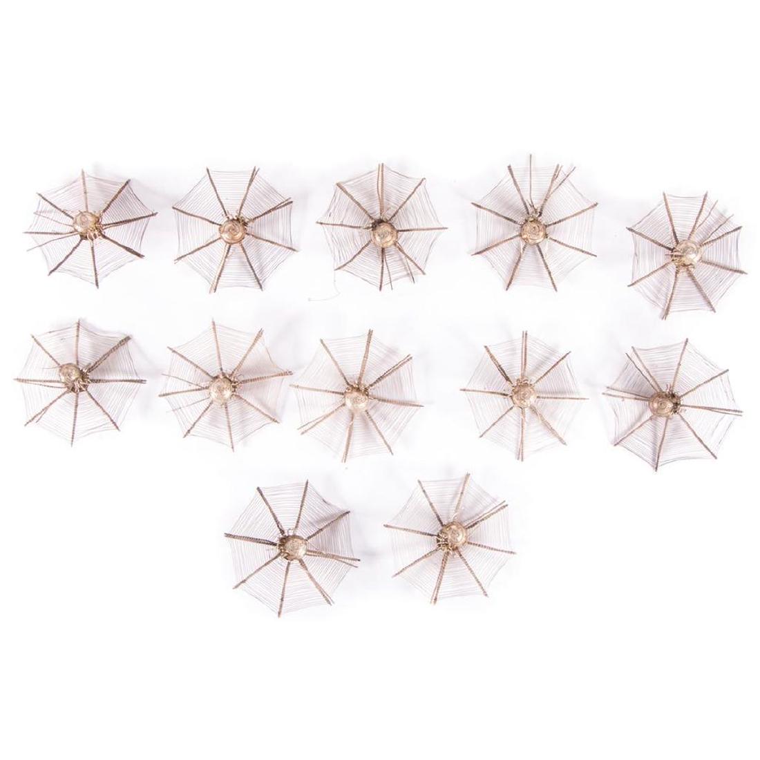 A set of twelve Chinese Spider silver place card: A set of twelve Chinese Export silver spider place card holders circa 1900 each measuring 3 inches in diameter. Approx. 70 grams.
