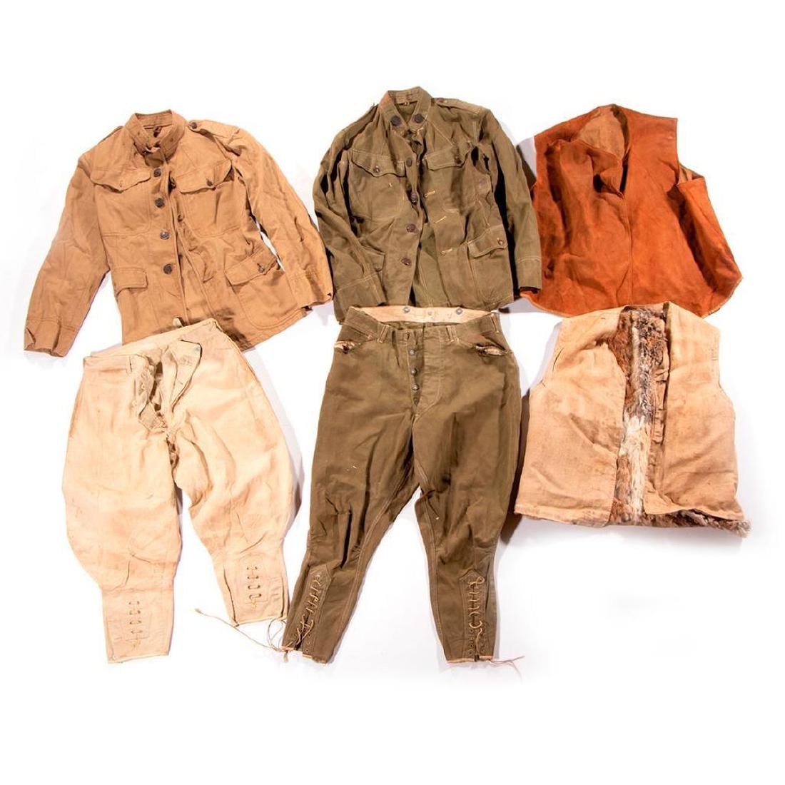 Two WWI military vests and two WWI military tunics and: World War I vests, tunics and pants: a rabbit skin vest, a possible Ballon Corps vest, a World War I US Army Balloon Corps green uniform tunic and pants, a tunic, and a pair of possible WWI pants.