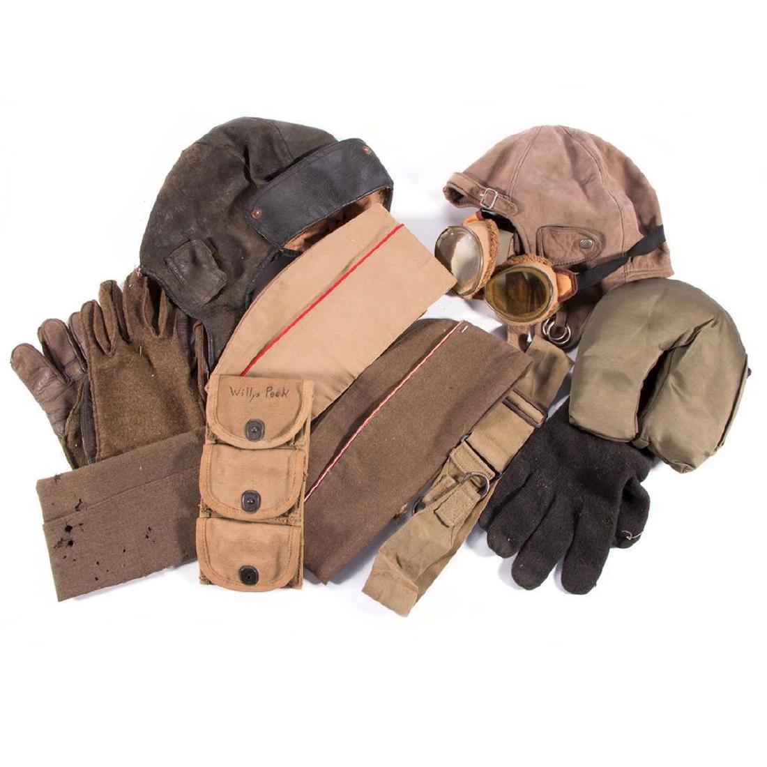 A collection of WWII militaria.: Various World War II American military equipment: two flight hats, one with flight goggles, a pair plus one flight gloves, M-1 ammunition pouches, a Musette bag strap, a neck rest and three below be