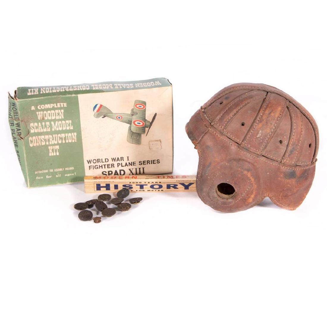 A lot of vintage items.: A 1930's football helmet, a wooden model airplane set, a history teaching measuring stick and a collection of buttons.