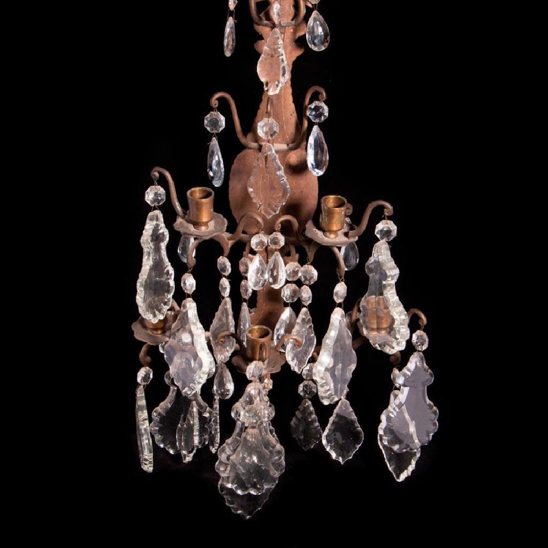 A pair of iron and crystal sconces.: A pair of iron and crystal sconces measuring 23 inches high x 11 wide x 9 deep.