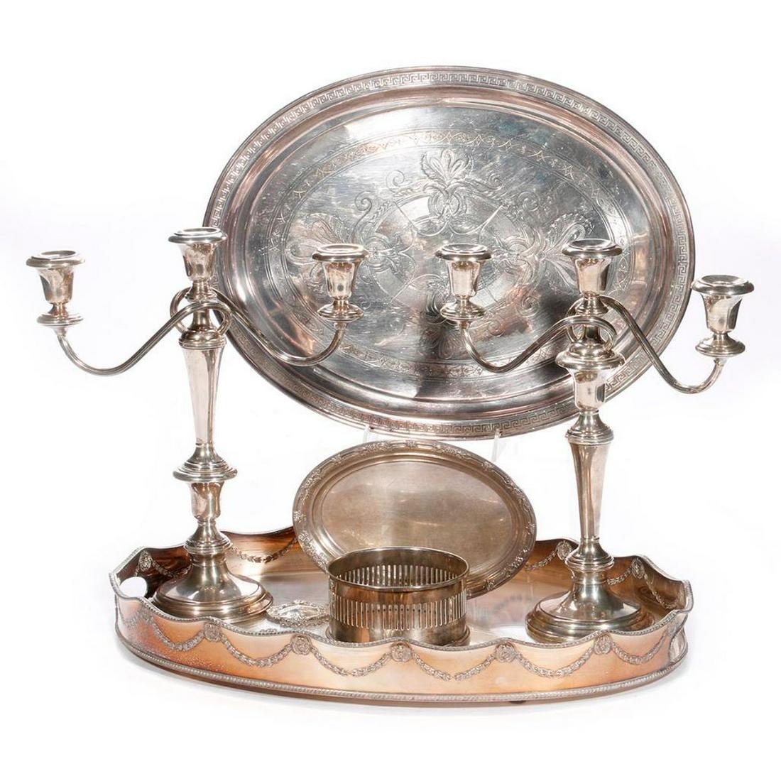Fourteen pieces of silver plate.: Fourteen pieces of silver plate: Four trays, two trivets, two wine casters, two candelabras (weighted sterling), and four decanter labels.