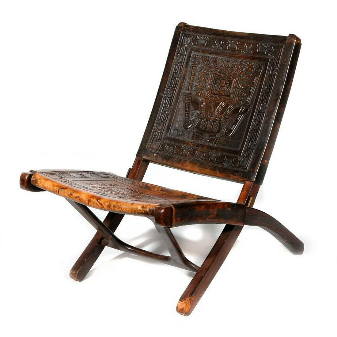 Peruvian wood and leather chair: c. first half 20th century, with impressed designs based on pre-Columbian models, leather seat and back, measuring 15 inches at the seat x 28 rail x 27 wide x 30 deep.