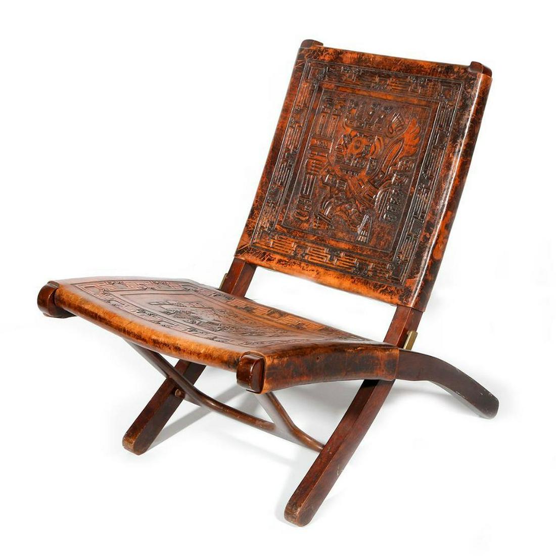 Peruvian wood and leather chair: c. first half 20th century, with impressed designs based on pre-Columbian models, leather seat and back, measuring 15 inches at the seat x 28 rail x 27 wide x 30 deep.