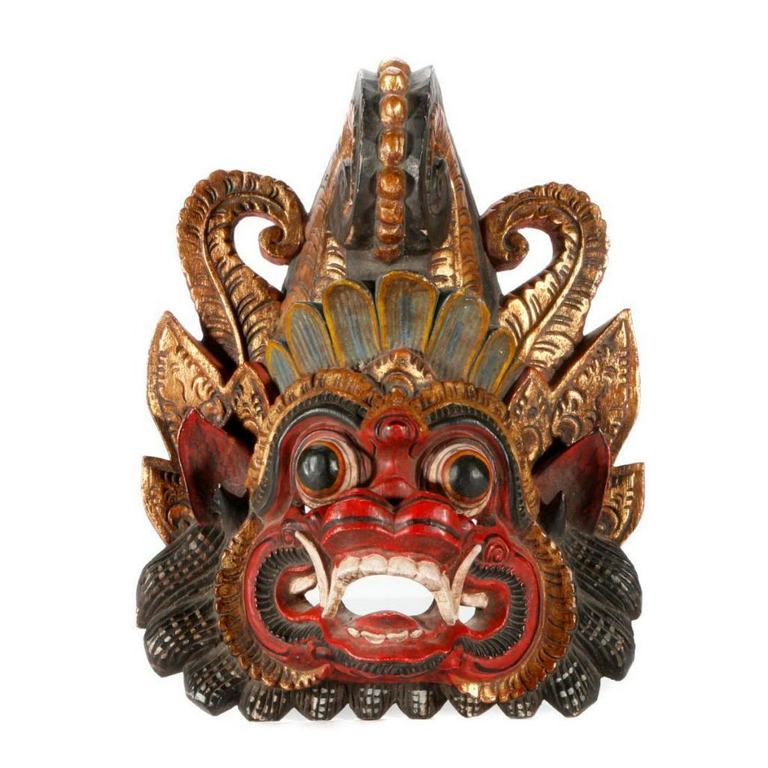A Balinese mask.: A carved wood Balinese mask measuring 14 inches high x 10 1/2.