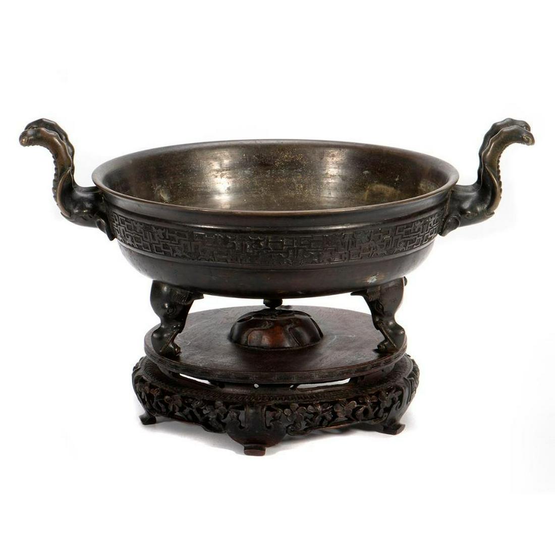 19th Century Chinese Bronze Tripod Censer: A bronze twin handled tripod censer, c.19th Century. Formed with three Elephant shaped legs, rising to a pair of curved handles cast as an elephant's trunk, incised mark on base. Size: 8" x 12".