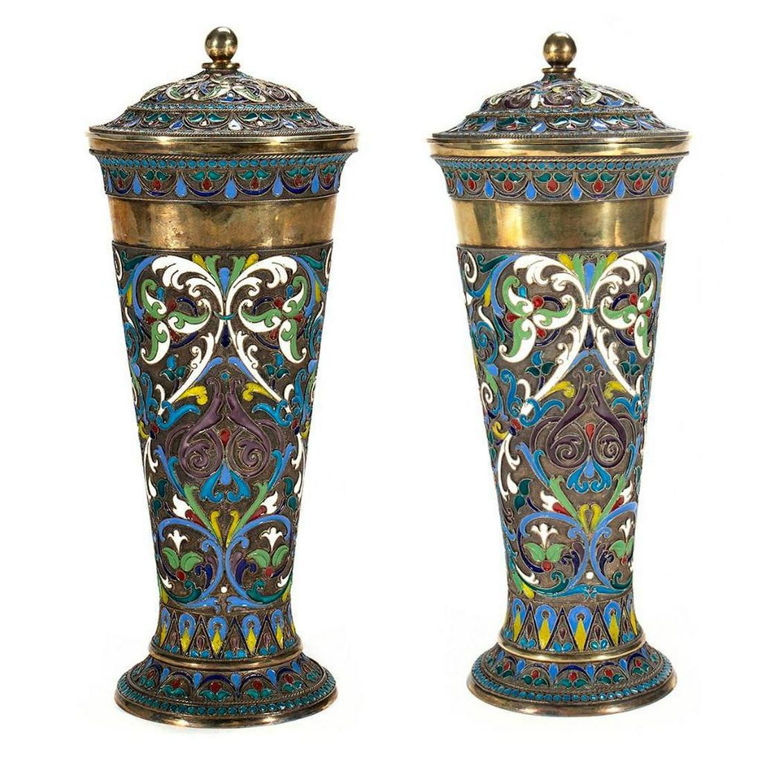 Russian Enamel Silver Beakers: A Pair of Early 20th-century Russian Enamel Silver Lidded Beakers covered with floral patterns and gilded inside. Russian Hallmarks. Size: 11.25 in. each. Overall condition good.