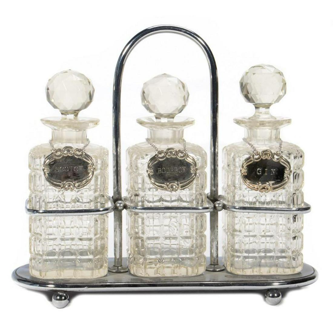 A Victorian Style Cut Glass Suite of Liquor Bottles: The three with silver plate badges in an Art Deco caddy. 12in. (30cm) h. Condition: Very good
