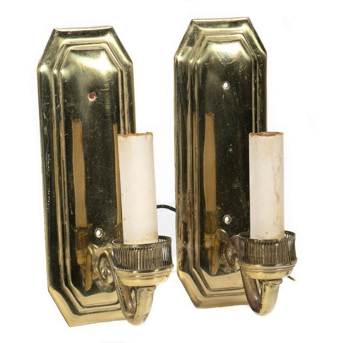 Pair of Neoclassical Brass Sconces: The arched candle cups fronting a rectangular reflecting back plate. 10in. (26cm) h. Codition: Minor tarnish. Faux candles need replaced.