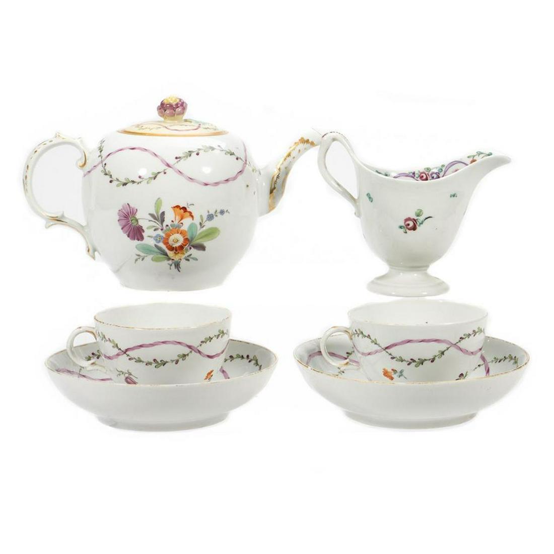 Contiental Sevres Style Tea Set: Including a tea pot, creamer, two cups and two bowls all decorated with delicate floral meander. Greatest height 6in. Condition: Teapot lid possibly associated, but good fit. small chip to interior ri
