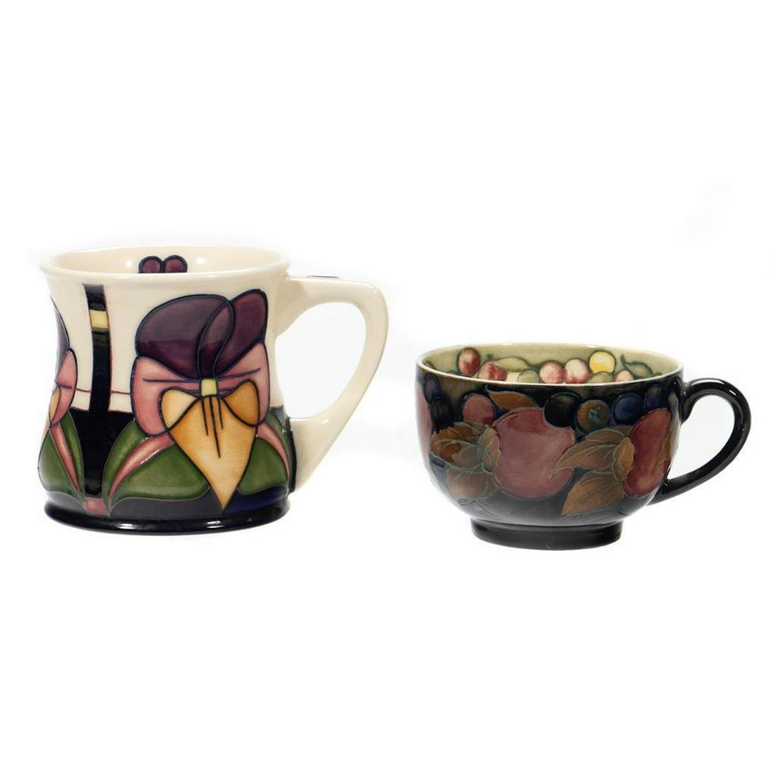 Moorcraft Pottery: A Teacup decorated in the Spanish Pattern and a Coffee Mug with Jack in Pulpet design. Greatest height 3 1/2in. (9cm) Condition: Good, no chips or cracks, minor staining to interiors.