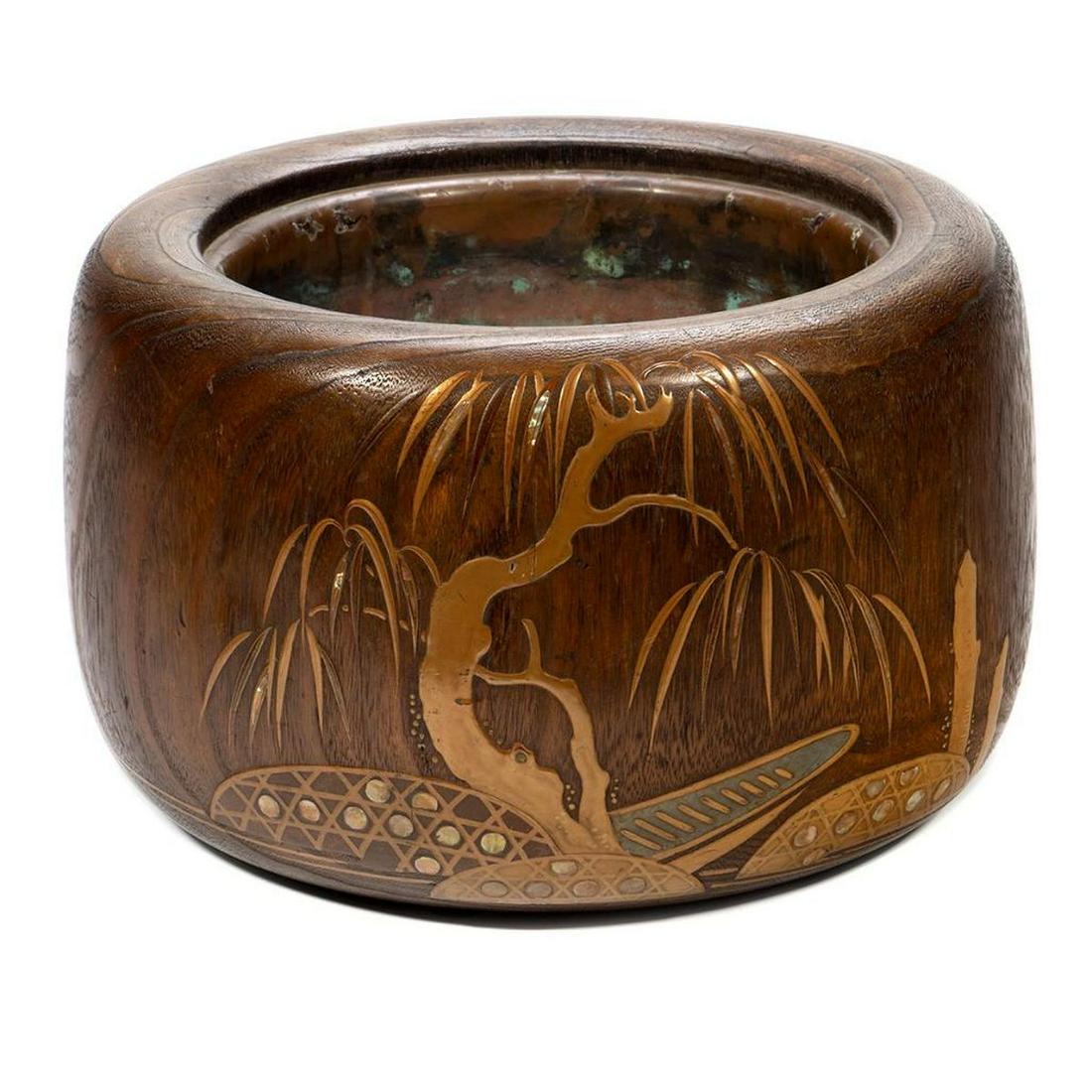 A Japanese Brass inlaid Jardiniere: Foliate design of brass and shell with a copper liner. 8 1/2in. (22cm) h. 13in. (33cm) d. Condition: Good, some wear to liner.