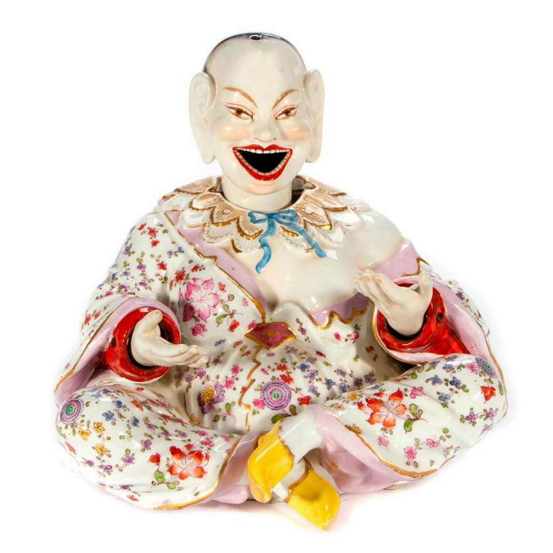 A Continental porcelain nodder.: A Continental porcelain nodder pagoda figure with articulated hands and head and crossed sword mark. H - 11" W - 11" D - 11". Condition: Good, metal crossbar on one hand missing and old repair to on