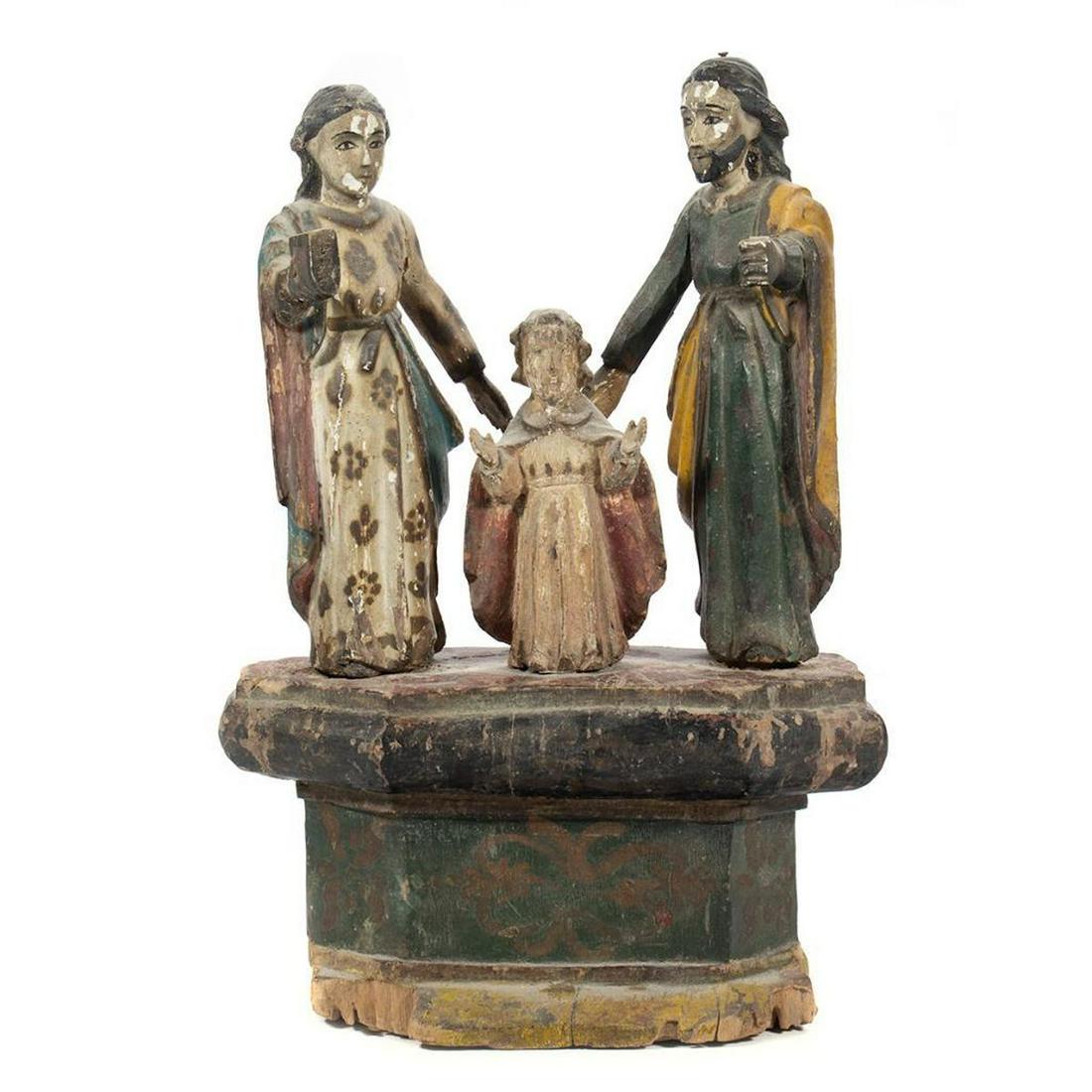 Spanish Colonial Carved Figures: Polychrome painted depicting the Holy Family on a plinth base. Total height 13 1/2in. Condition: Wear to paint. Old repair to one arm of each standing figure.