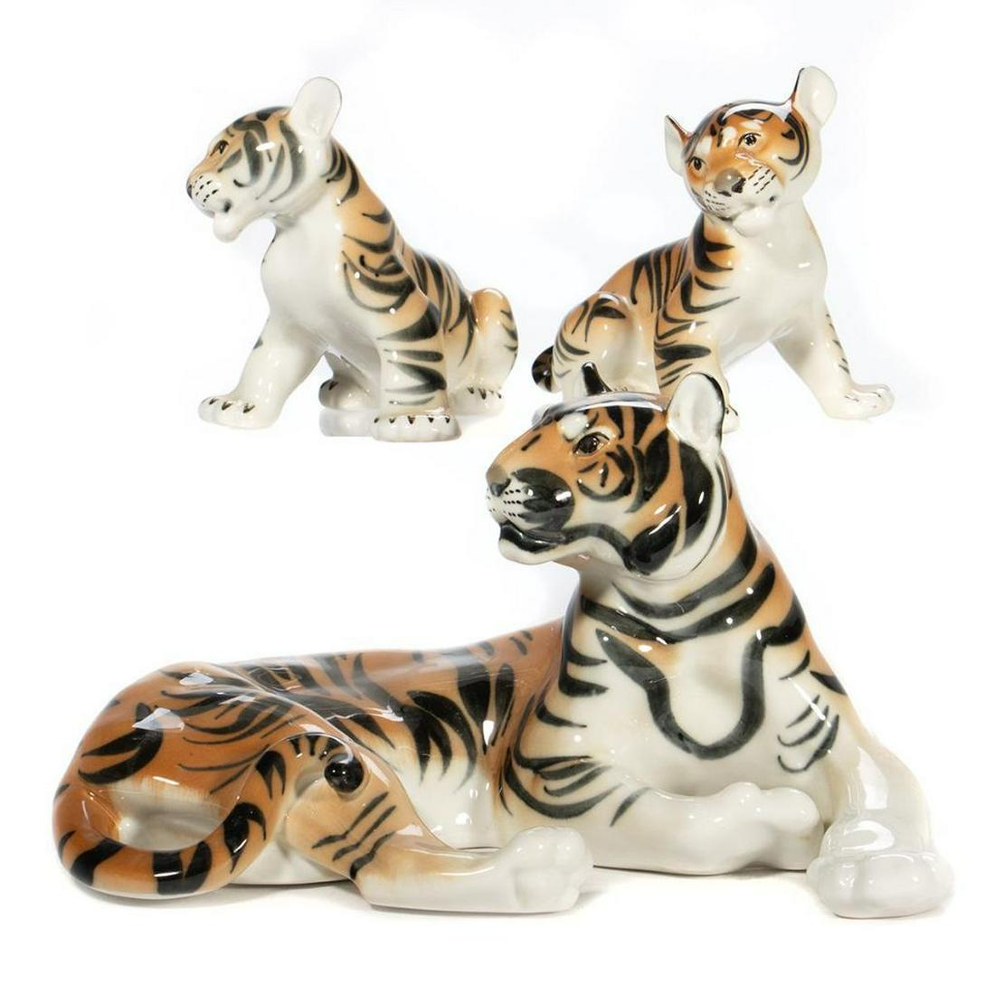 Russian Lomonosov Porcelain Tiger Group: Including an adult tiger and two cubs. Greatest height 7in. Greatest length 10in. Condition: Very good, no chips or cracks. Red stamp on base. 'Made in USSR'