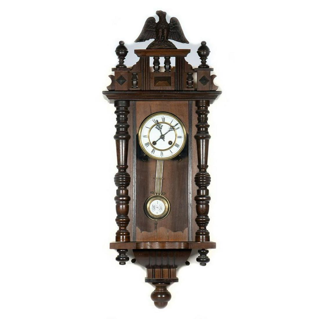 Victorian Pillar and Scroll Wall Clock: Enclosing a white enamel dial with Roman chapter ring. 34in. h. 13in. w. 5in. d.