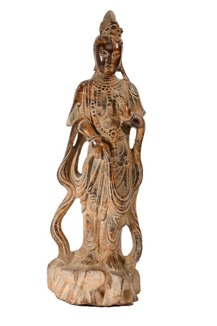 Brownstone Guanyin Figure, 20th Century.: Mottled brownstone figure of Guanyin wearing flowing robes and standing on rockwork; height 22in. 20th Century. Condition: the head broken off/repaired.