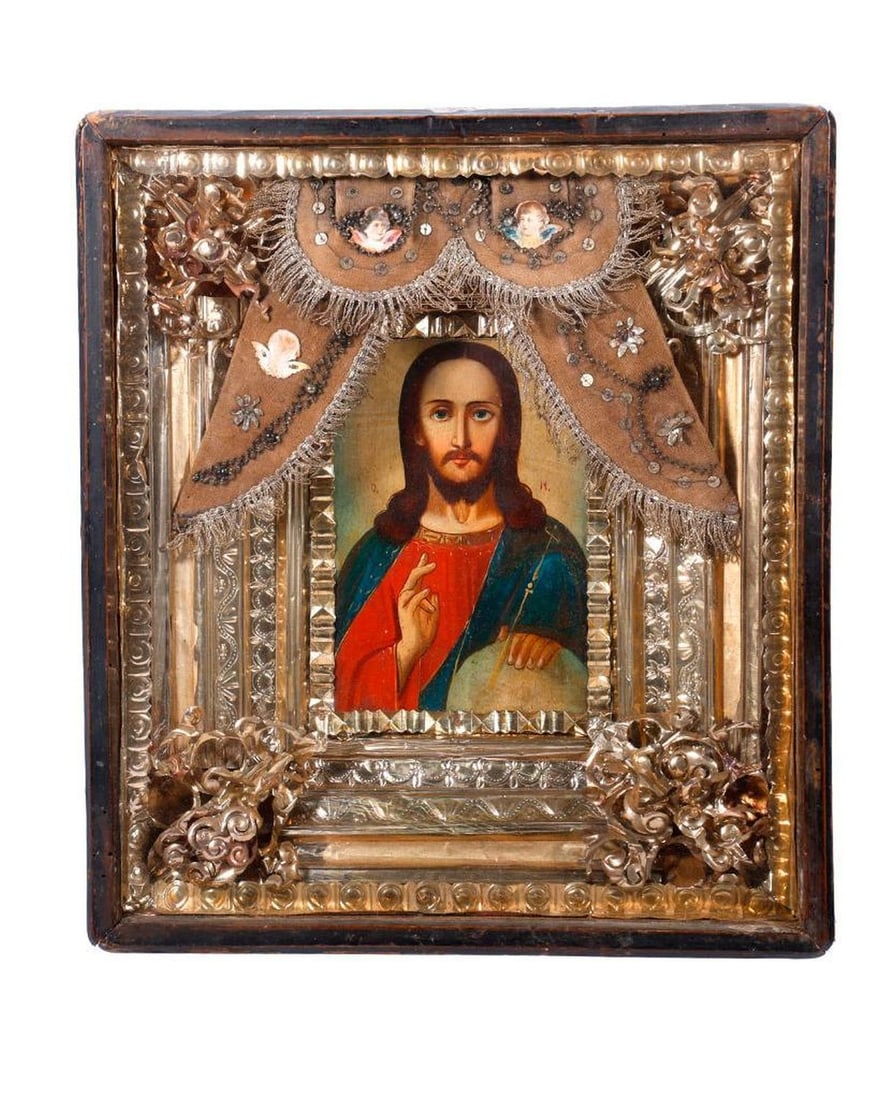 An Icon of Christ Pantocrator in Kiot.: Eastern Europe, 19th/20th Century. A painted icon of Christ Pantocrator with globe, with ornate foil liner and altar curtains embellished with beading, trim, and paper angels, in a rectangular shadowb