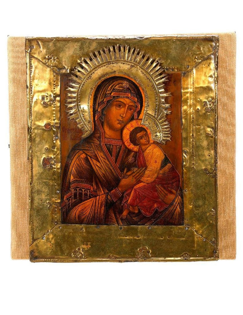 An Icon of the Virgin of the Passion.: Eastern Europe, Circa 20th Century. An icon of the Theotokos as Virgin of the Passion, tempera on wood panel, with brass border and halo; 12"x 10 1/4". Condition: overall good, some holes in border, d