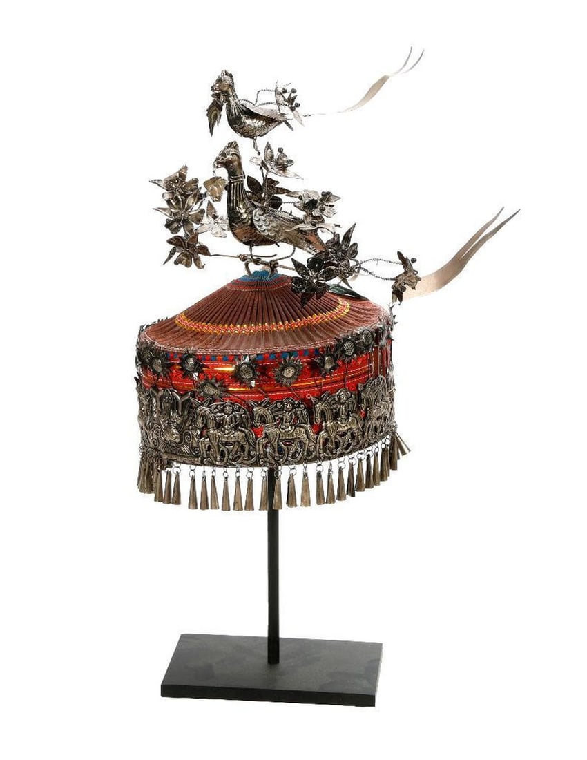 Chinese Miao Culture Headdress.: The vintage Miao ceremonialcap/headdress with a pleated silk top and embroidered bands, embellished with a relief silver metal band of a mythical creature and figures on horseback, and topped with a s
