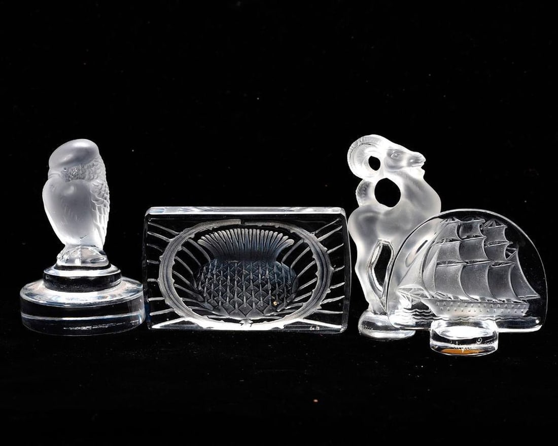 Four Lalique Crystal Decorative Objects: The collection of clear and frosted crystal objects/sculptures consists of an owl paperweight, a thistle knife rest, a clipper ship panel, and a ram figurine (the tallest 3 1/4"). All etchedLalique, F
