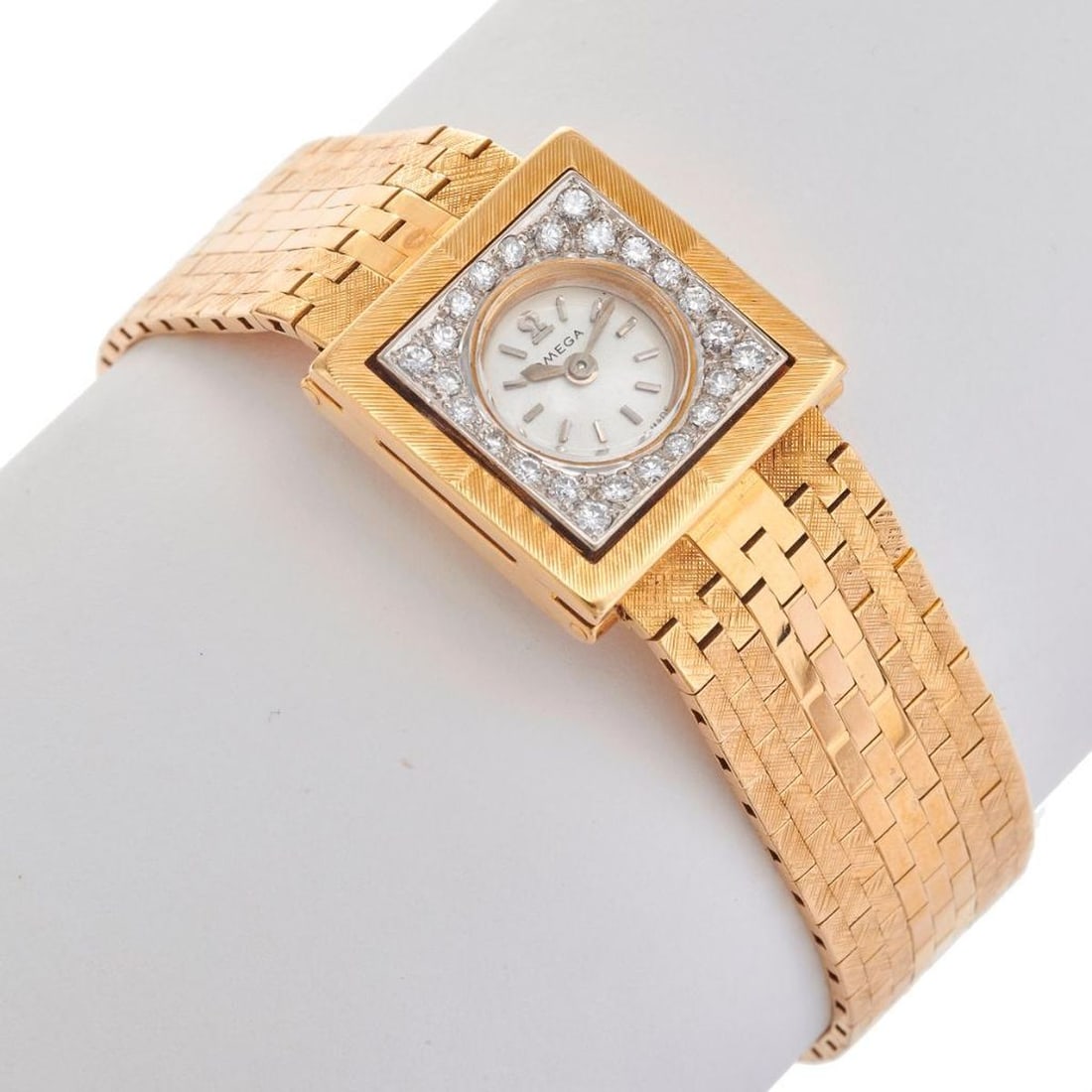 Omega, An 18k gold and diamond backwind wristwatch: square case, round dial framed with round brilliant-cut diamonds, backwind, case #11407743; weighing approximately 50.76 grams; overall length: 6 1/2 in; width: 18mm (movement not accessed). PLEASE NO