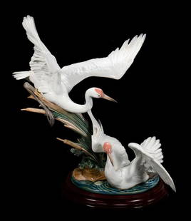 Lladro Courting Cranes Porcelain Sclupture: The figural porcelain sculpture of two cranes with spread wings; approx. 20 1/2" x 16" x 10". Condition: lower crane with old repair to one wing.