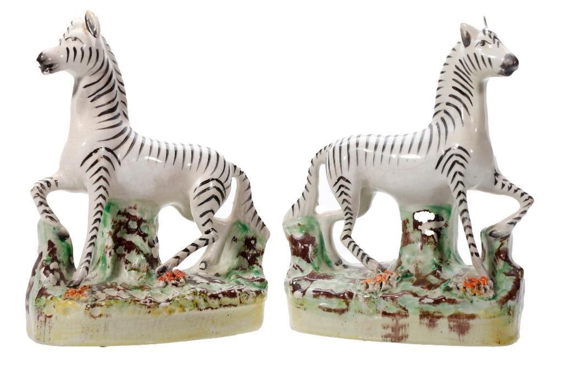 Pair of Staffordshire Zebras: 19th Century. A pair of Staffordshire pottery zebras, each standing with one raised leg on grassy circular bases. The tallest approx. 6 1/2" x 2" x 4 3/4". Condition: overall good; one with tiny chip 