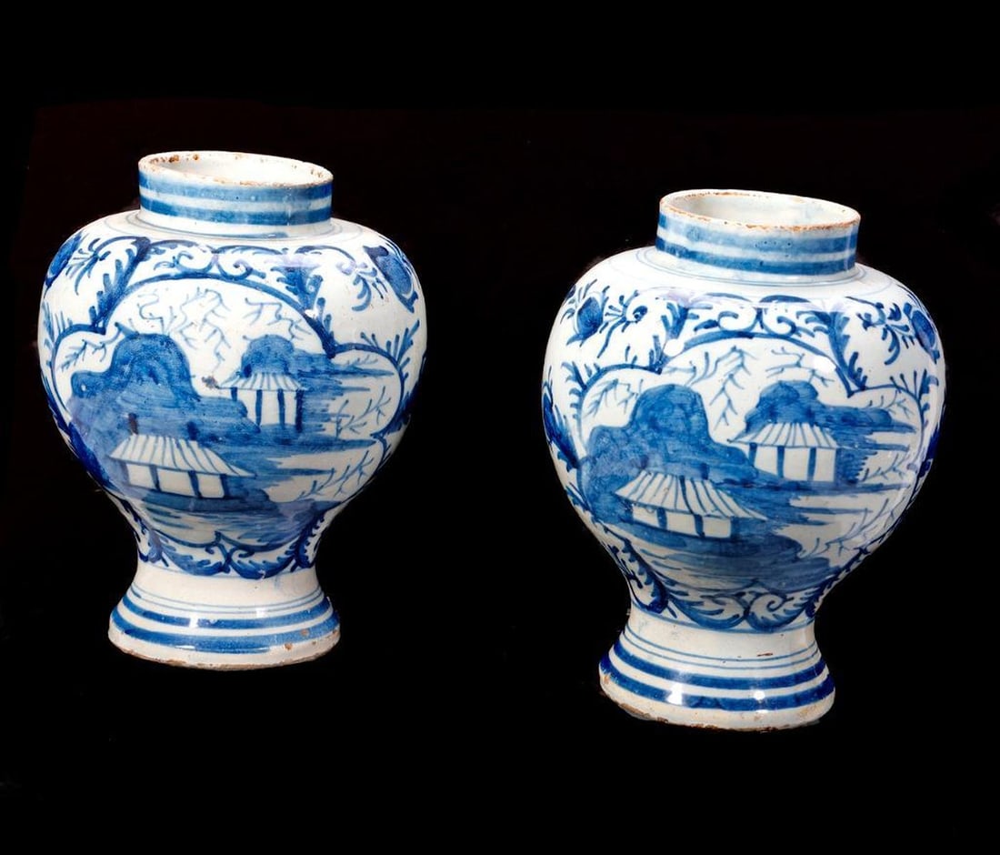 Pair of George II Delftware Vases. Property of Alton F. Irby III: The pair of blue on pale blue bulbous-form vases with Chinoiserie decoration of houses in a landscape within a cartouche, surrounded by scrolling foliage. Condition: both have areas of old glaze resto