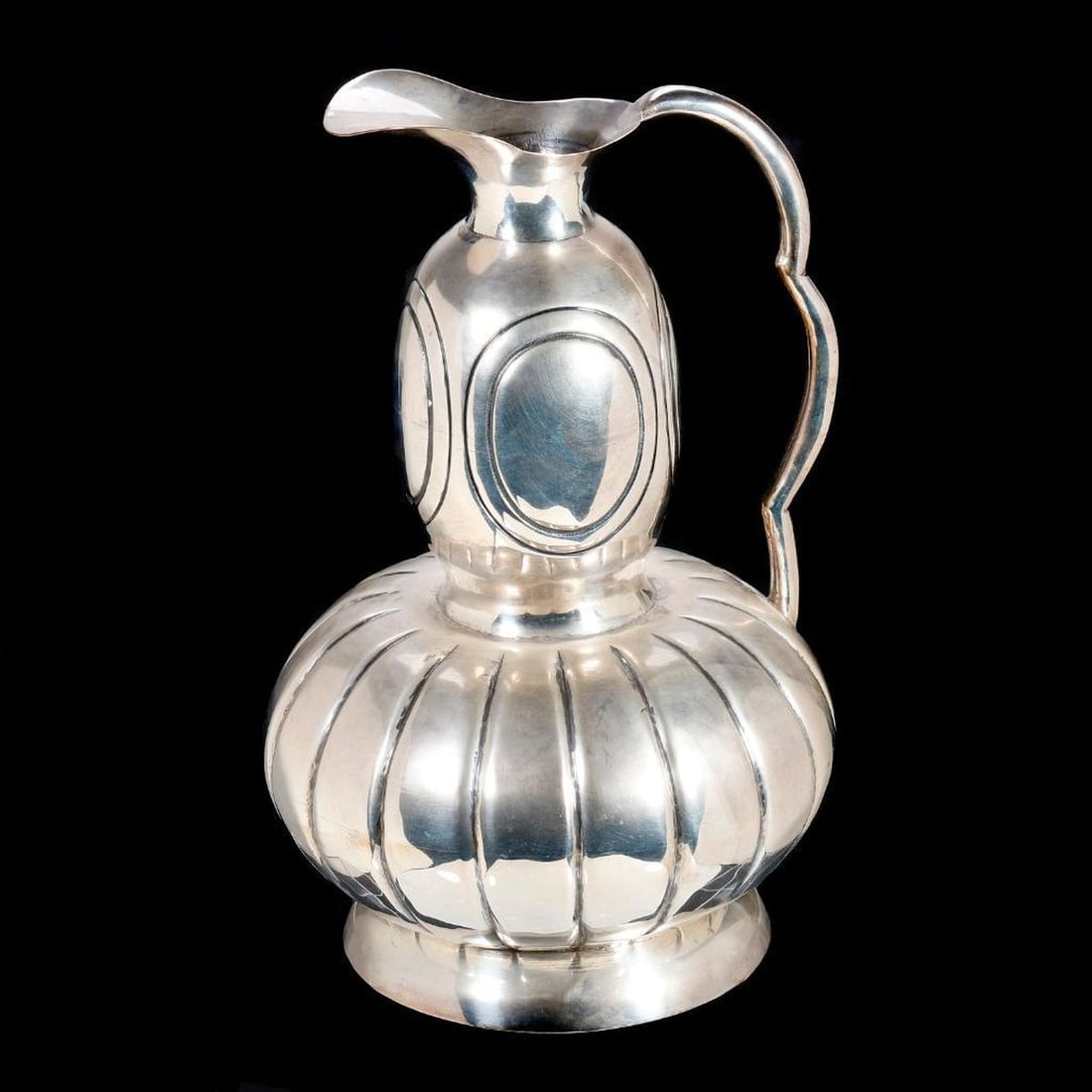 Mexican Modernist Silver Pitcher: Juan Jose Segura (1901-1964). A Mexican silver pitcher designed/signed by the artist on base. Handle with rubbed silver marks, and maker: "Diaz." 10 1/2" tall. Approx. 1027 grams.