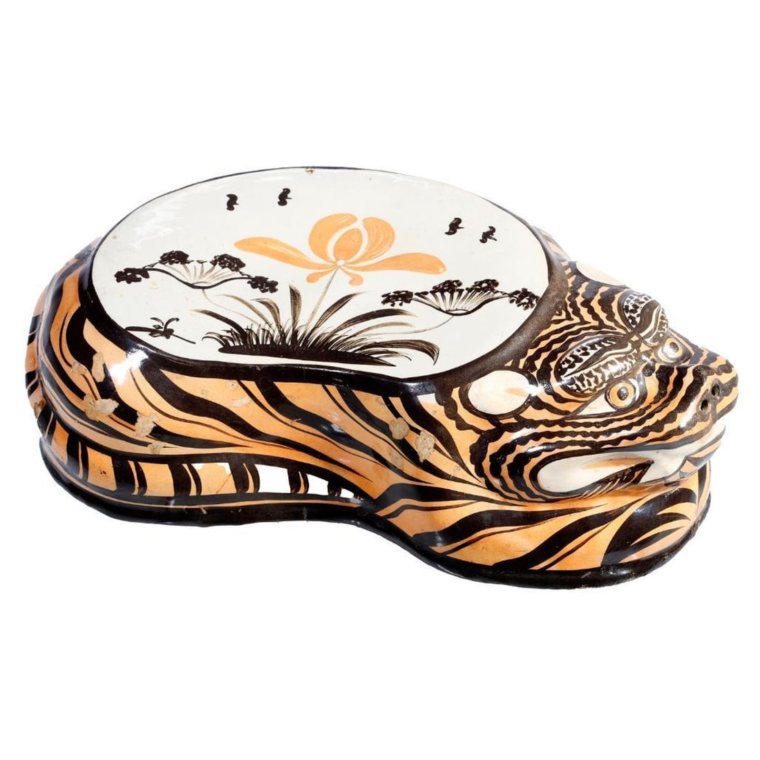 Chinese Stoneware Cizhou Tiger Pillow, c. 19th Century: The stoneware pillow in the form of a tiger with bared teeth and a staring gaze; with brown stripes on orange-beige ground, and an iris-decorated flat rest surface, all over white slip, with a clear g
