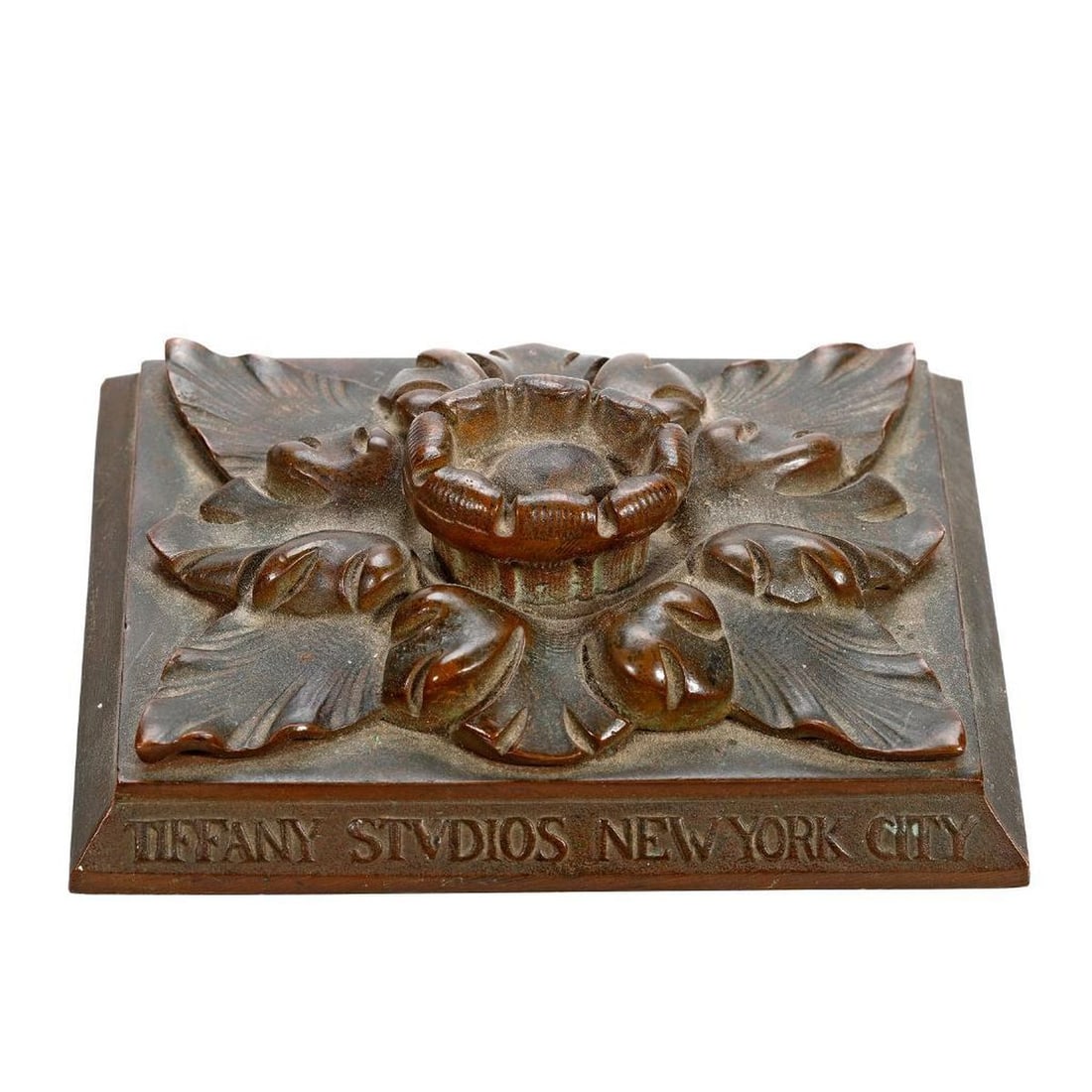 Tiffany Studios New York City Paperweight: The rectangular form weight surmounted by a floriform handle above leafy surround, the front titled in raised letters "TIFFANY STVDIOS NEW YORK CITY', 1.5"h x 5"w x 4"d. Overall good condition consist