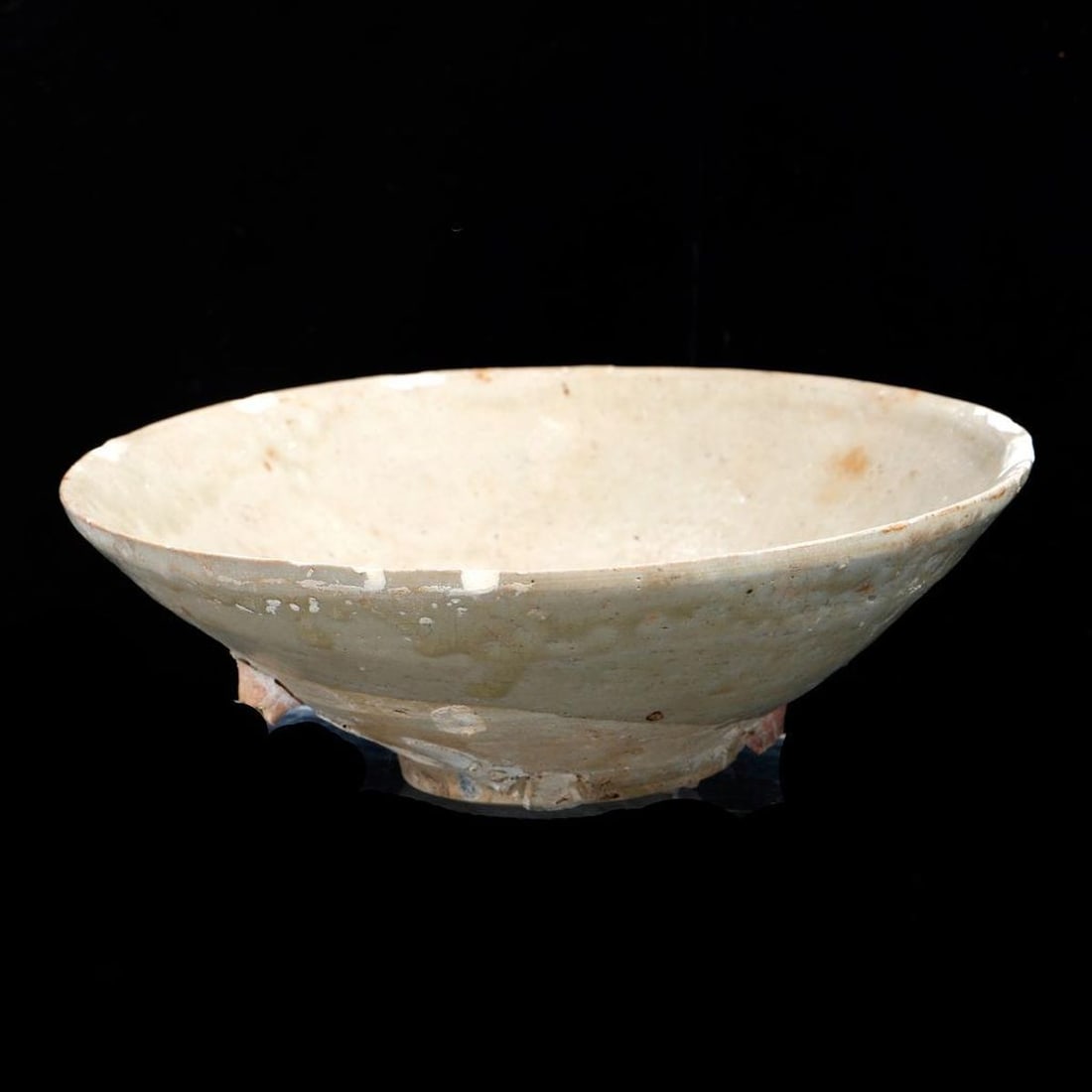Chinese Shipwreck Encrusted Celadon Bowl: Possibly Yuan Dynasty. The conical form with a runny pale gray glaze and a biscuit foot, 2.5"h x 6.5"d (the interior side wall with a .5"d muscle shell scab mark as well as scattered small kiln adhesi