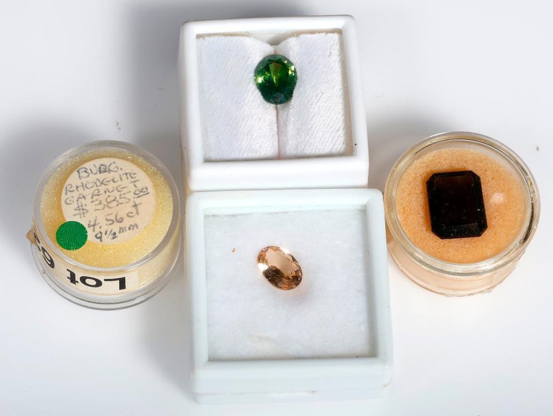 An group of unmounted gemstones: including moonstone, blue topaz, pink beryl, green garnet, citrine, rhodolite garnet, enstatite, and moldavite; weighing in total approximately 250 carats