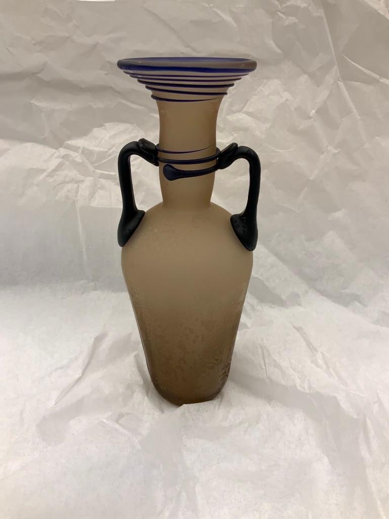 CCAA GLASGALERIE KOLN Double-handled Glass Vessel: Reproduction of antique glass, pitcher shaped with blue spiral around neck and lip, blue handles, frosted light brown glass. 8 x 3 1/2 x 3 inches (20.3 x 8.9 x 7.6 cm) Provenance: CCAA Glass Gallery C