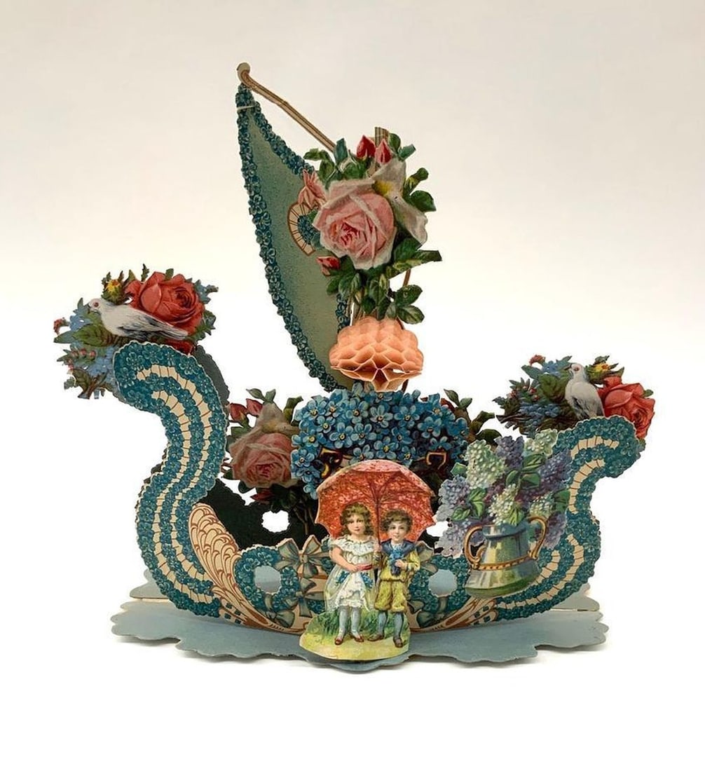 Valentine Card: pop-up, sailboat: Pop-up Valentine with color illustration of flowers in shape of a sailboat, young couple with umbrella on front, two doves on right and left. Medium: paper, ink. Source: The Old Print Shop, Inc. Dimen