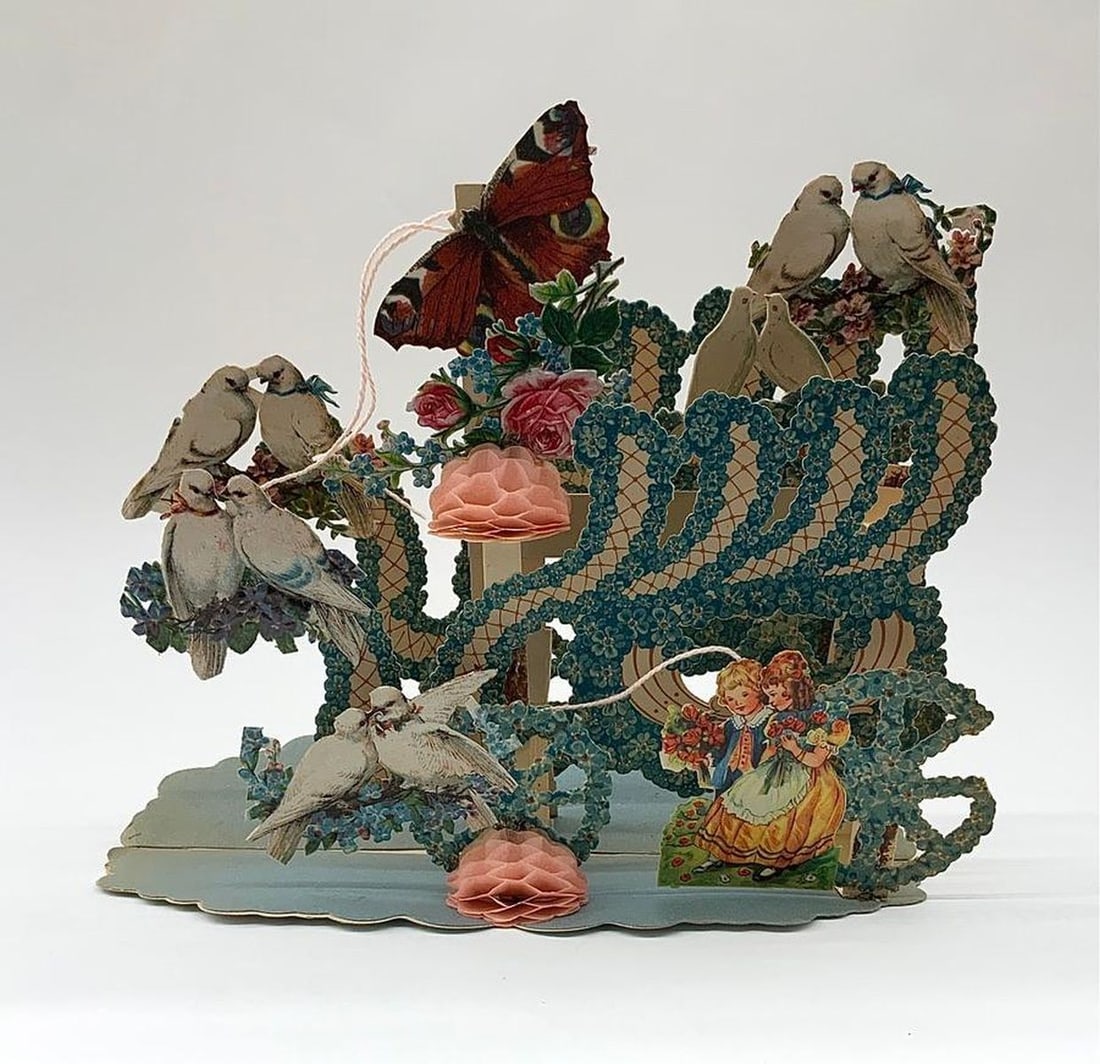 Valentine Card: pop-up, carriage with doves: Pop-up Valentine with color illustration of flowers in shape of a carriage, young couple on front with various doves and butterfly. Medium: paper, ink, string. Source: The Old Print Shop, Inc. Dimensi