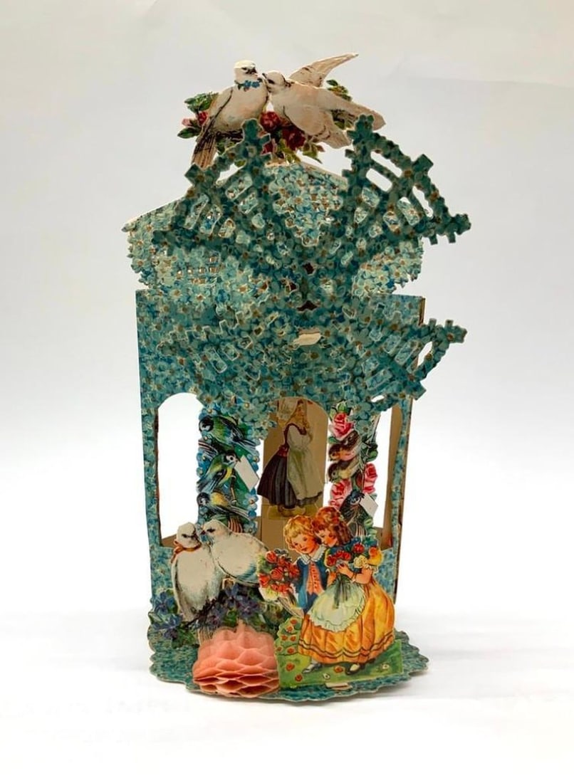 Valentine Card: pop-up, windmill: Pop-up Valentine with color illustration of floral gazebo/windmill with a young couple, two doves and pink honeycomb ball in the foreground, open windmill blades on center and two doves on top. Medium