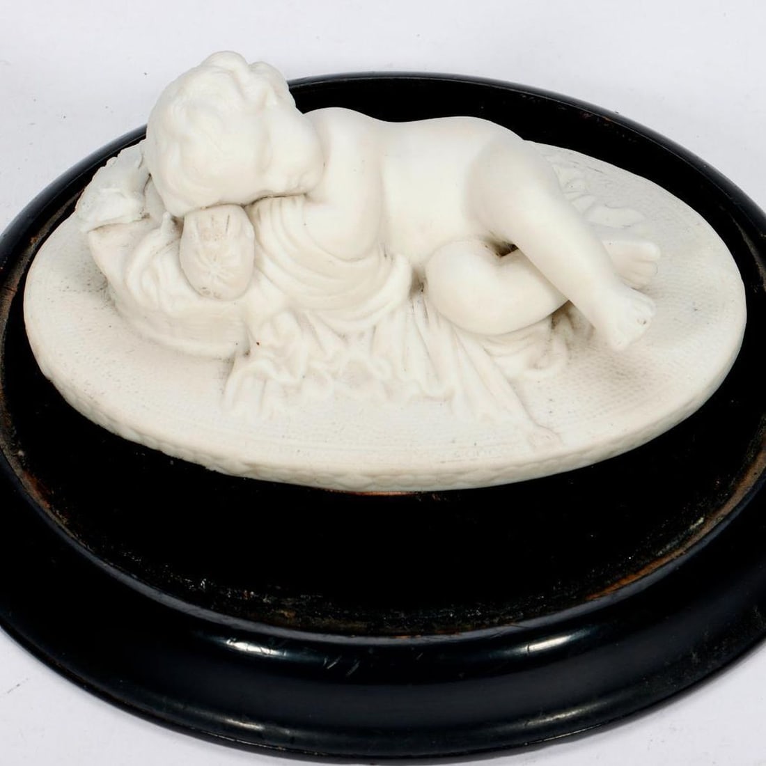 Three European Blanc de Chine Figures of Child or Infant Christ: Comprising a sleeping child (losses to leafy floral bocage and two Italian white glazed creche figures of the infant Christ, the three figures displayed in two glass domes. Larger figure 3in. h.