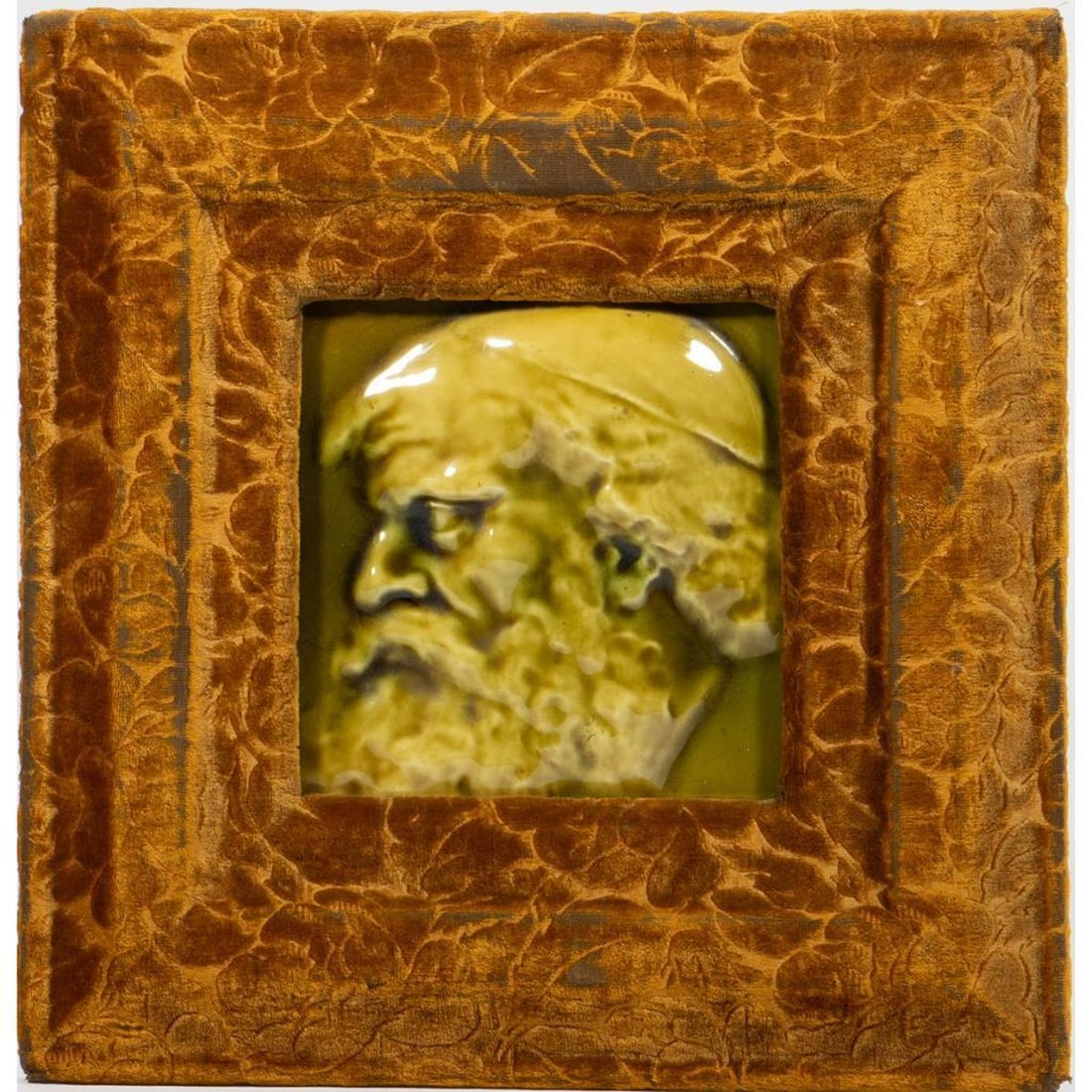 Framed Portrait Tile of Old Man, Late 19th/Early 20th Century: Likely Trent Tile Co. The olive green relief tile is framed in a gold velvet-covered wood frame. Tile is approx. 6in. x 6 in. (5 1/2in. x 5 1/2in. sight); the frame 11 3/4in. x 11 3/4in. Condition: