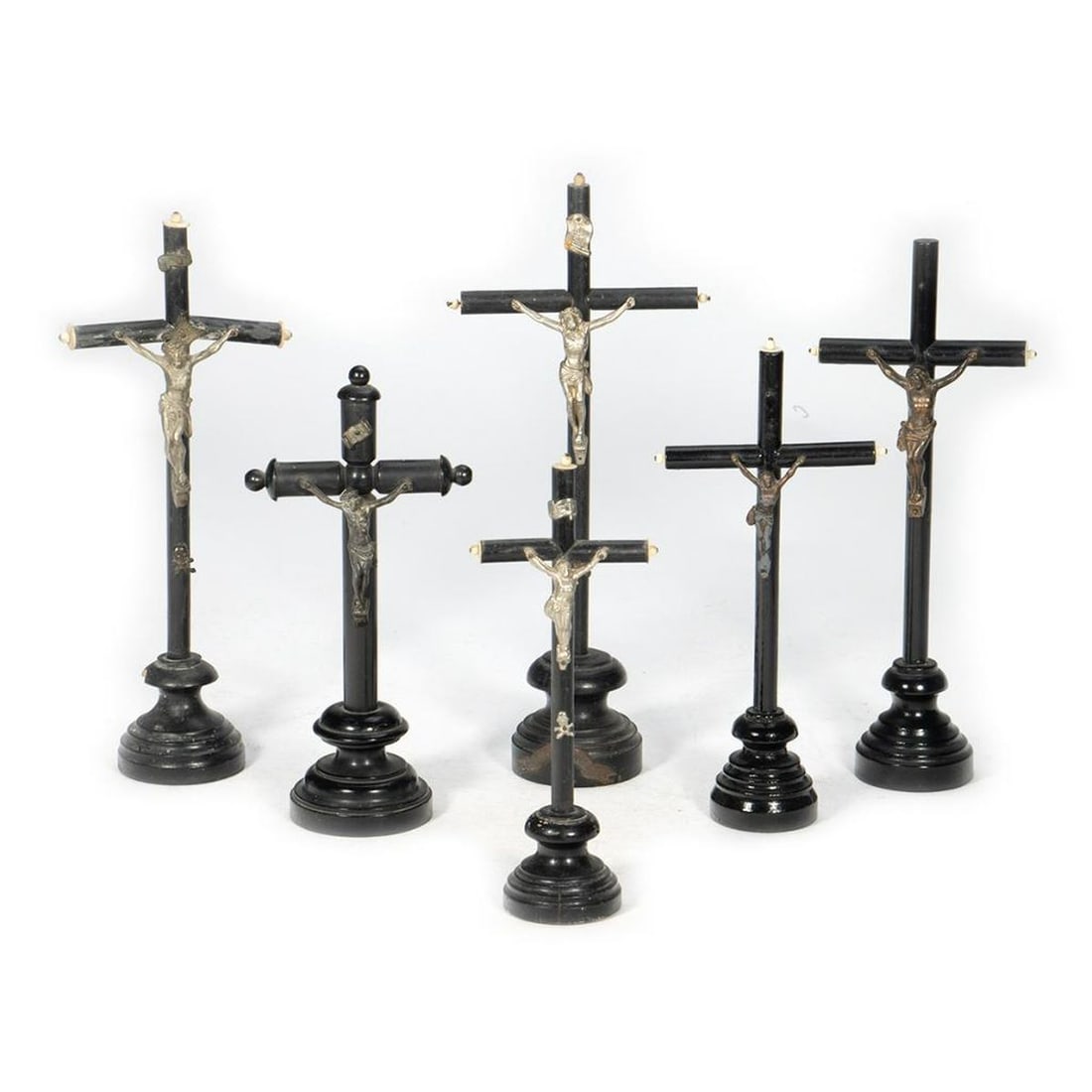 6 Souvenir Standing Wood Crucifixes: Each wooden cross painted black, with metal figure of Christ. Some with wear. Ranging in height from 8 1/2in. to 12 3/4in.