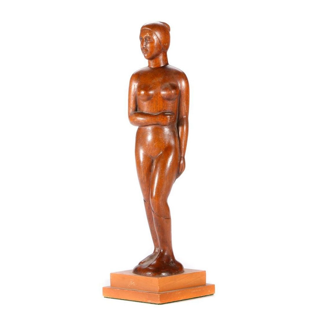 Art Deco Carved Wood Nude Figure: Circa 1930s/1940s. A carved wood figure of a standing female nude, slightly turned, one arm folded at her waist, her hair in a bun; mounted on base. Total height 15 inches. Condition: o
