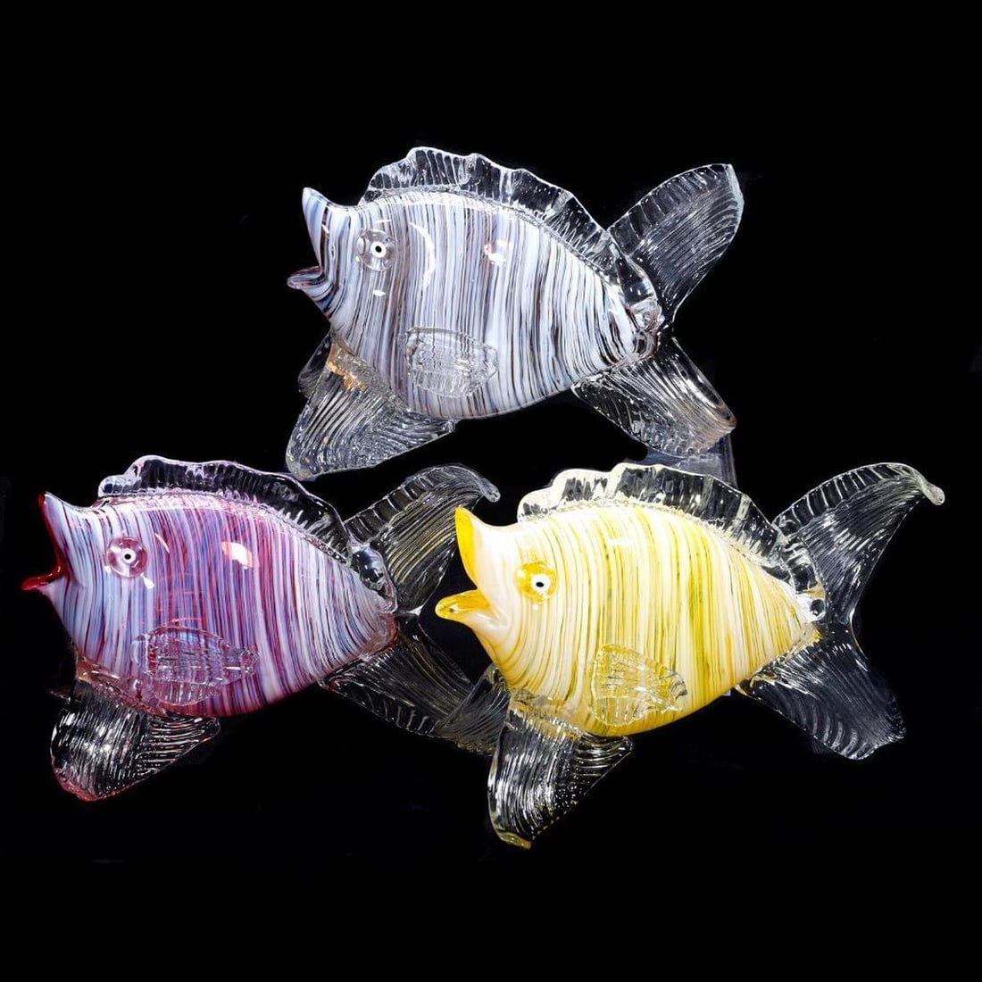 Three Murano Glass Fish Figures: A trio of Murano glass fish in white-striped yellow, pink, and purple. The slightly larger of the three measuring 5 3/4" x 8 1/2" x 4 1/2". All in good condition. [Turtle not photoed]