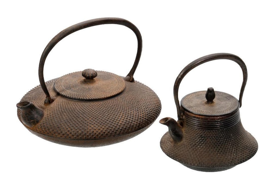 Two Japanese Cast-Iron Teapots: The larger tetsubin with lid stamped "Japan" and bottom side of pot with character stamp; height 3 1/4"; circumference approx. 7". The smaller of tapered form, unmarked; height 3 1/4"; circumference