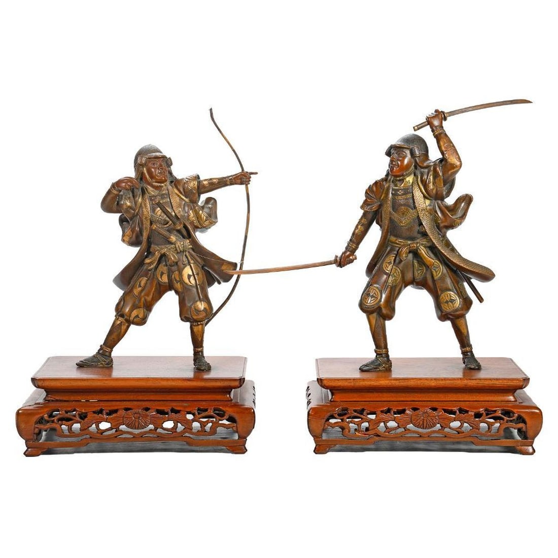 Pair Japanese Miyao Style Bronze and Mixed Metal Figures of Warriors: Meiji Period. Bearing inlaid signature of Watanabe, the pair standing warriors, elegantly garbed in a robe, one actively brandishing a pair swords, the other drawing a bow, each on a carved wood
