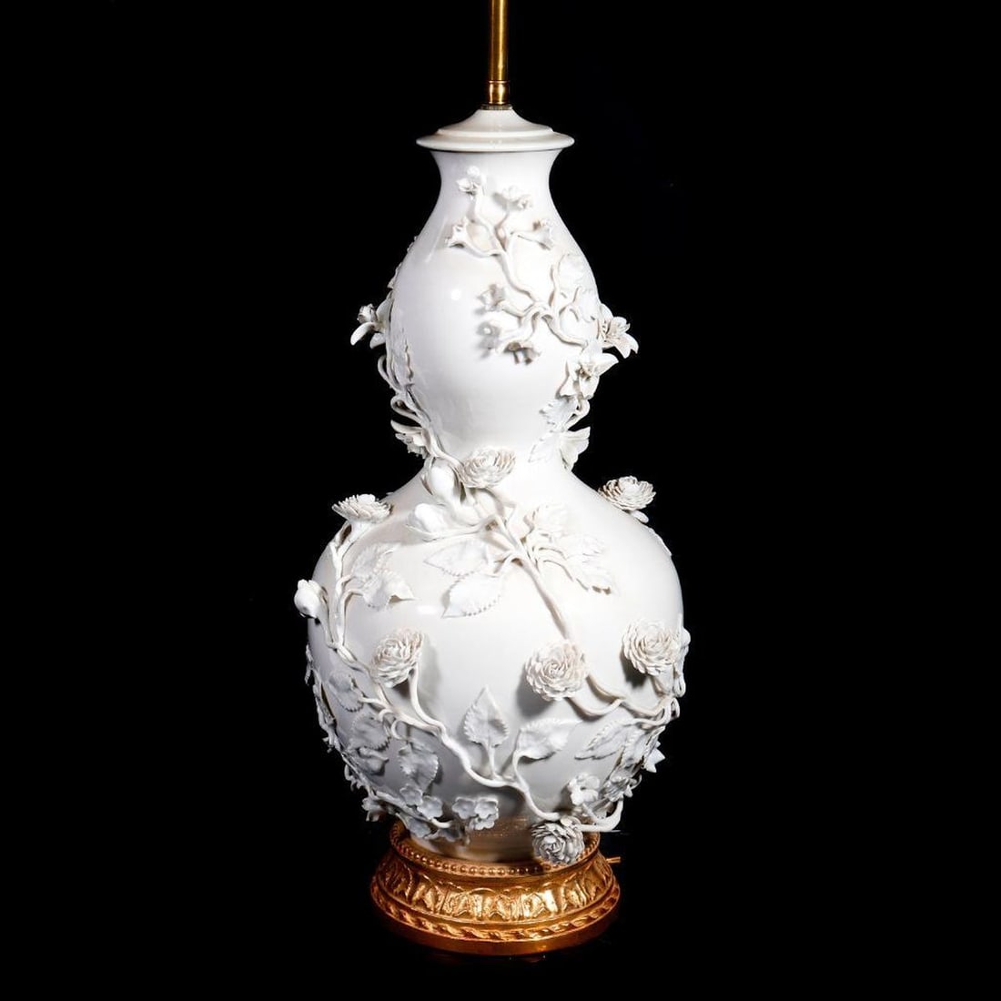 Chinese Blanc De Chine Floral Encrusted Porcelain Lamp: Qing Dynasty, of double gourd form, allover encrusted with blossoming dahlias or roses on a leafy vine tendrils, fitted with a contemporary gilt wood base, the contemporary brass lamp standard with a