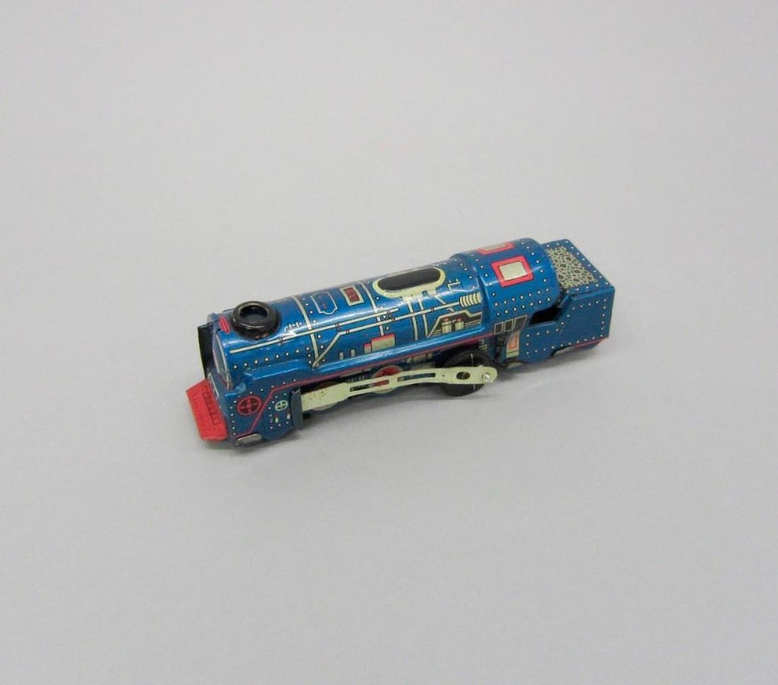 Vintage Blue locomotive: Small blue toy locomotive toy train.Dimensions: 1 3/4 x 1 1/4 x 5 1/4 inches (4.4 x 3.2 x 13.3 cm) Condition: Small bend on PL "back door". Side rods are bent. Rust on interior wheels. Scratches