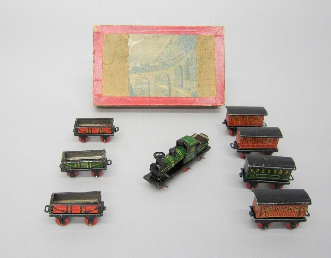 Boxed Train Set: Comprising mini toy trains; locomotive No. 291, tender, four coaches and three wagons en suite with an original compartmentalized box; illustration of train and landscape. Dimensions: 1 x 6 1/2 x 4